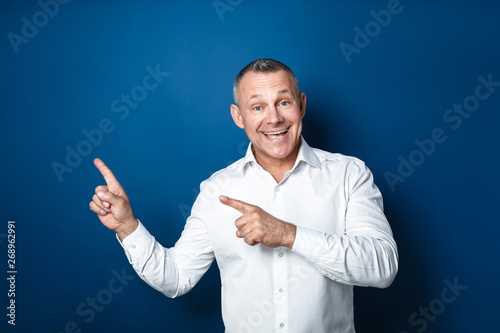 Happy middle-aged man point...