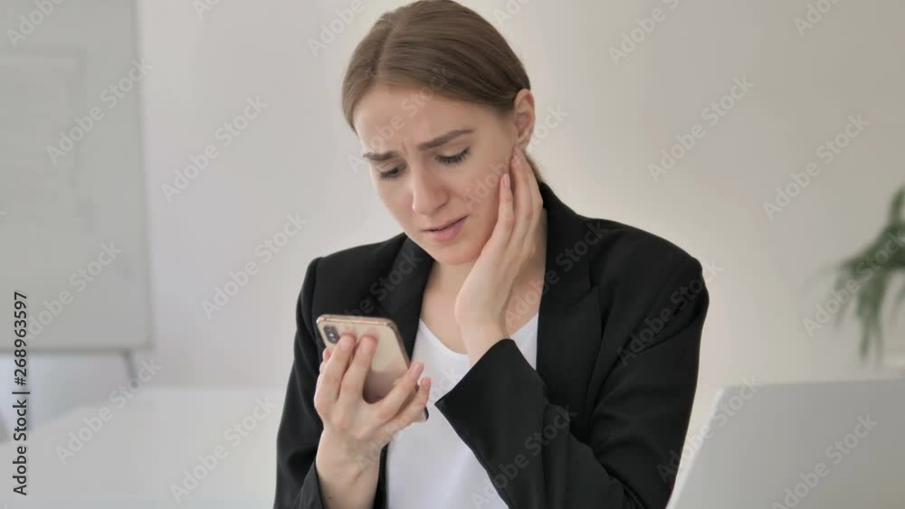Young Businesswoman Upset by Loss on Smartphone Young Businesswoman Upset by Loss on Smartphone
