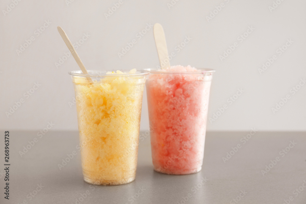 Cups with tasty shaved ice on grey table Cups with tasty shaved ice on grey table