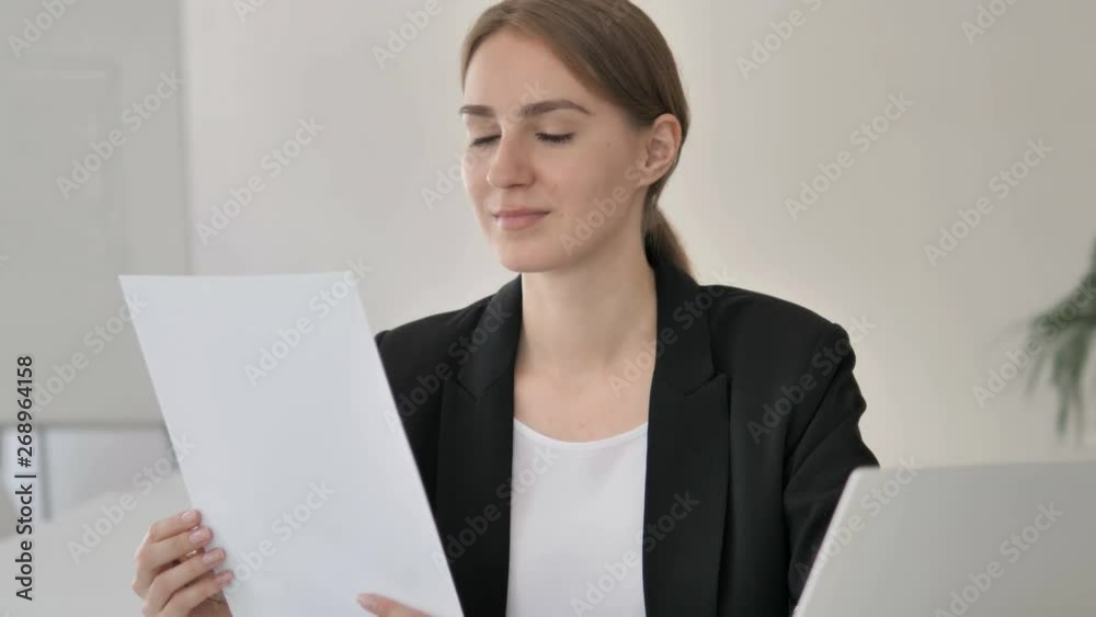 Young Businesswoman Reading Documents at Work Young Businesswoman Reading Documents at Work