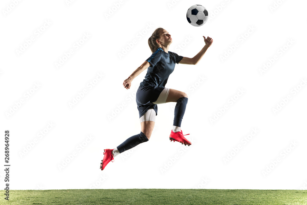Young female football or soccer player with long hair in sportwear and boots kicking ball for the goal in jump isolated on white background. Concept of healthy lifestyle, professional sport, hobby. Young female football or soccer player with long hair in sportwear and boots kicking ball for the goal in jump isolated on white background. Concept of healthy lifestyle, professional sport, hobby.