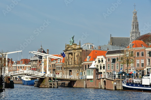 The Spaarne riverside, with Teylers Museum, Gravestenenbrug bridge and the clock tower of St Bavokerk Church in the background, Haarlem, Netherlands