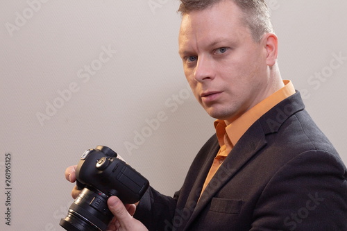 Young male video cameraman, photographer, shoots video or takes a photo on the camera.