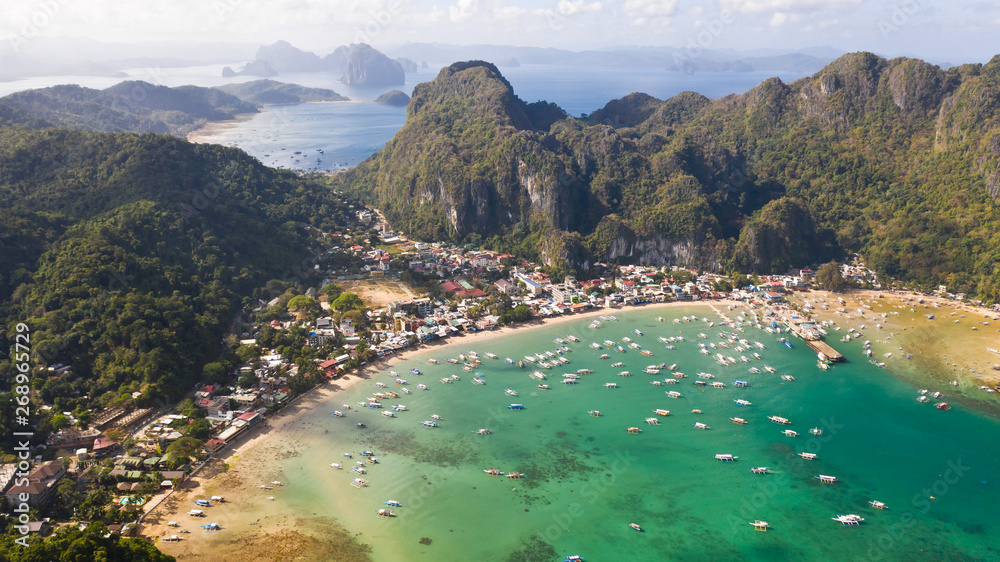 Many boats in the turquoise lagoon. Seascape with blue bay and boats view from above. El nido, Palawan, Philippines. traditional Filipino wooden outrigger boat called a banca. Summer and travel