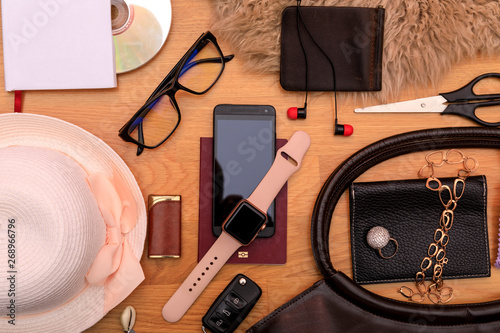 Travel concept. Key, headphones, passport, hat, sunglasses, watch and bag on wooden desk.