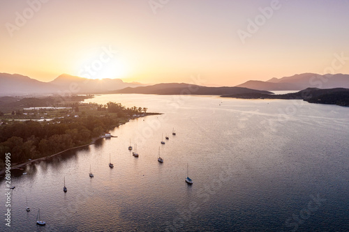 yachts are on the water near the island. Golden sunset sun. Aerial photo