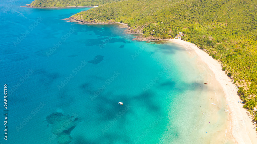 White sandy beach with palm trees and a beautiful lagoon.Landscape with a tropical beach, top view.