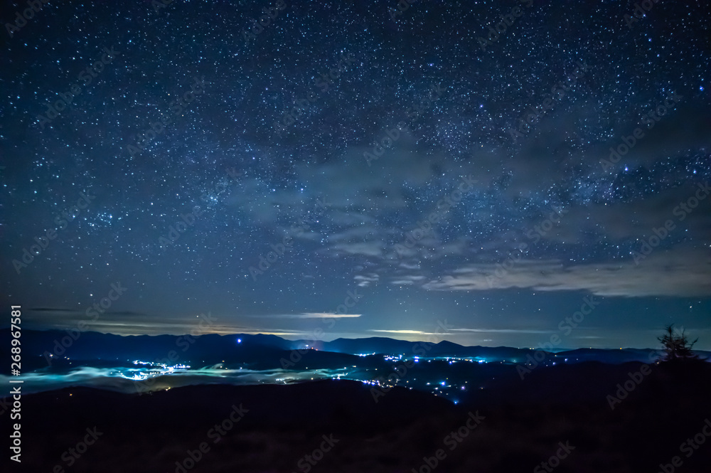Starry sky over the city in the fog