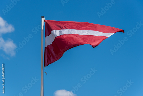 Latvian Flag on a Windy Day with a Sunny Sky