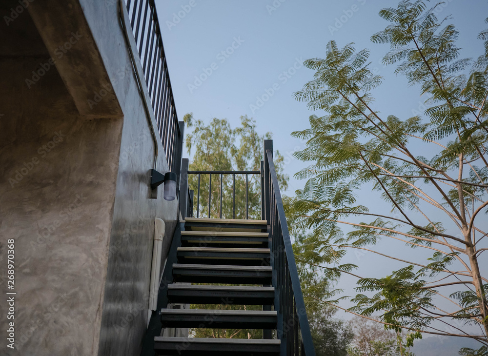 Obraz premium Stainless steel stairs outside the building with concrete wall.