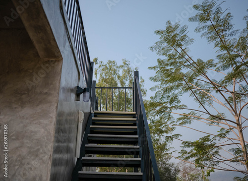 Stainless steel stairs outside the building with concrete wall.