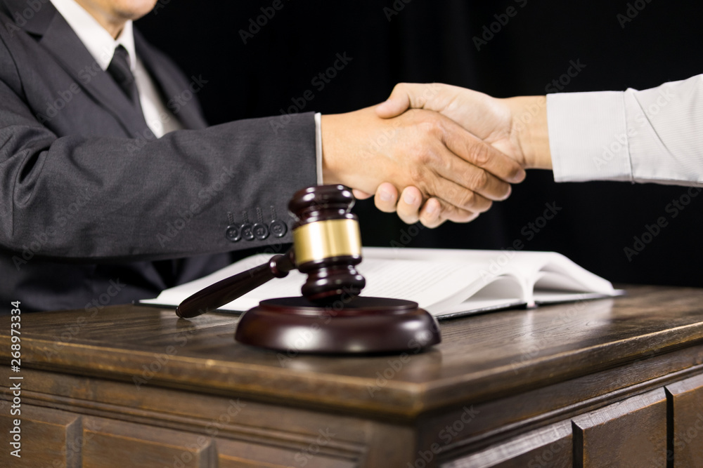judge and client shaking hands in background at courtroom after good cooperation having meeting or give legal advice attorneys discussing a contract agreement. judge and client shaking hands in background at courtroom after good cooperation having meeting or give legal advice attorneys discussing a contract agreement.