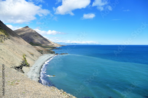 View of Iceland's intense blue sea water and shoreline in bright sunlight