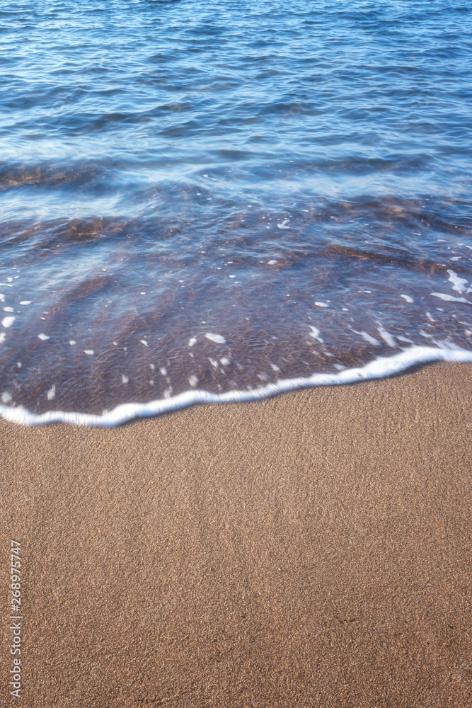 Sand beach and ocean or sea wave, nature background for your design with copy space, vertical image