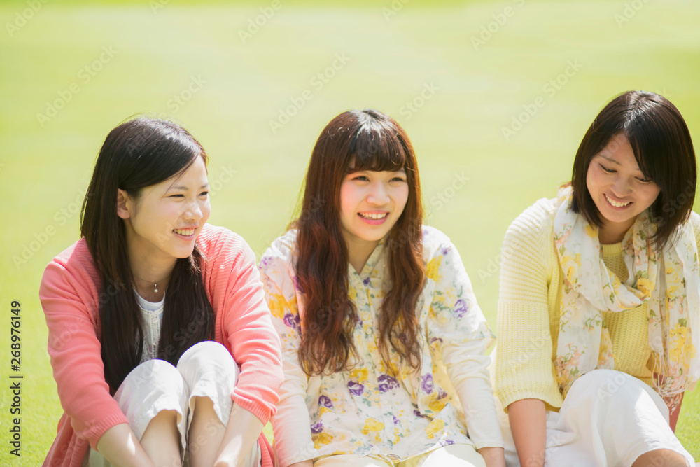 Obraz premium 草原で談笑をする大学生