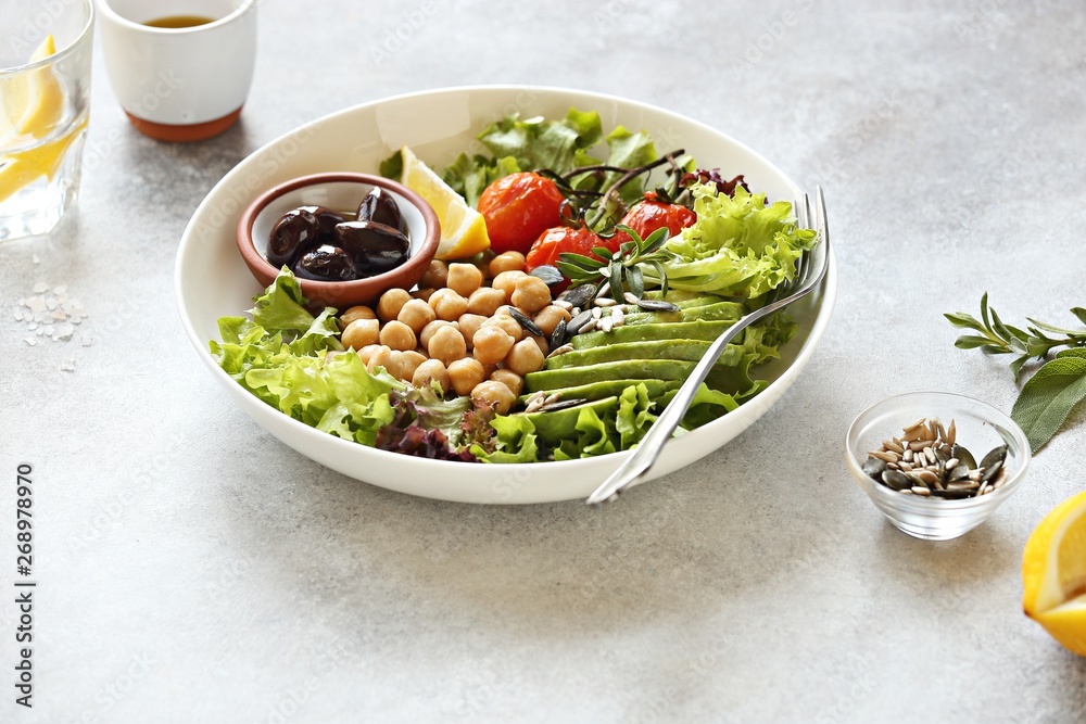 Detox salad with chick pea, avocado, grilled tomatoes and olives. Healthy salad bowl for super food, clean eating, plant based diet concepts.