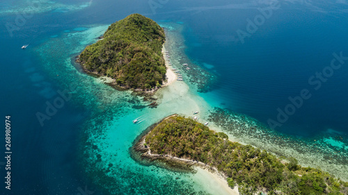 Paradise islands with white sand, palm trees and crystal blue water in Palawan, The Philippines