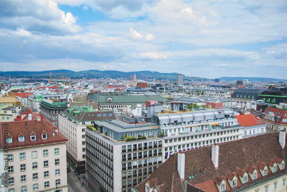 Landscape of Vienna Austria from the top of the tower with colorful roofs as aerial panoramic view with different buildings and mountains on the background as memory card from travel landmark 