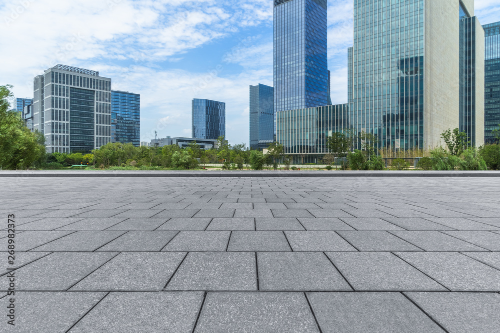 empty pavement and modern buildings in city.