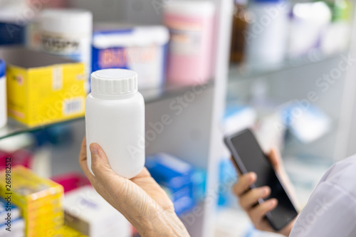 white medicine bottle in hand pharmacist