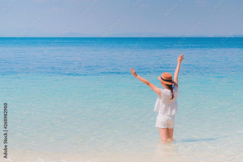 Traveler Asian woman feeling happy on the beach to the summer sea background with copy space.Concept of relax on vacation holidays. Traveler Asian woman feeling happy on the beach to the summer sea background with copy space.Concept of relax on vacation holidays.