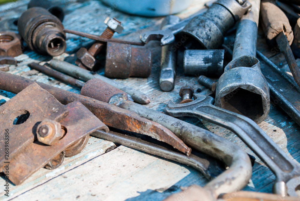 The old tool lies on the table, hammer, wrench, bolts, metal. The old tool lies on the table, hammer, wrench, bolts, metal.
