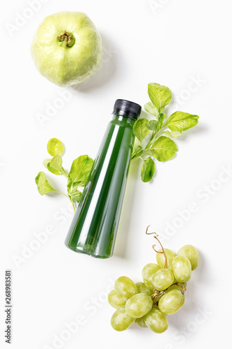 top view flat lay bottle of juice with spinach, green greape and guava on white background. Healthy lifestyle, vegetarian food concept. Detox photo