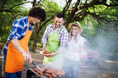 Young female and male couple baking barbecue in nature