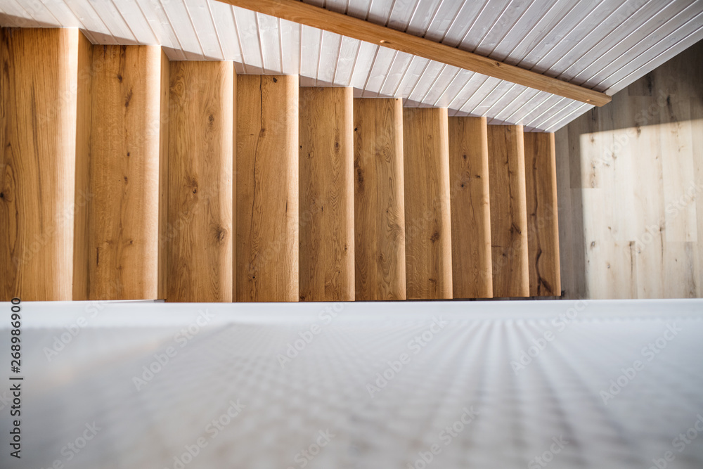 A top view of wooden staircase and white wall in an interior of a house. A top view of wooden staircase and white wall in an interior of a house.