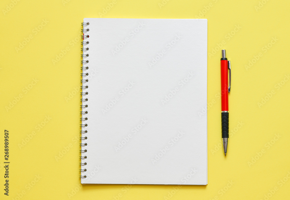White notebook in an office setting on a yellow background White notebook in an office setting on a yellow background