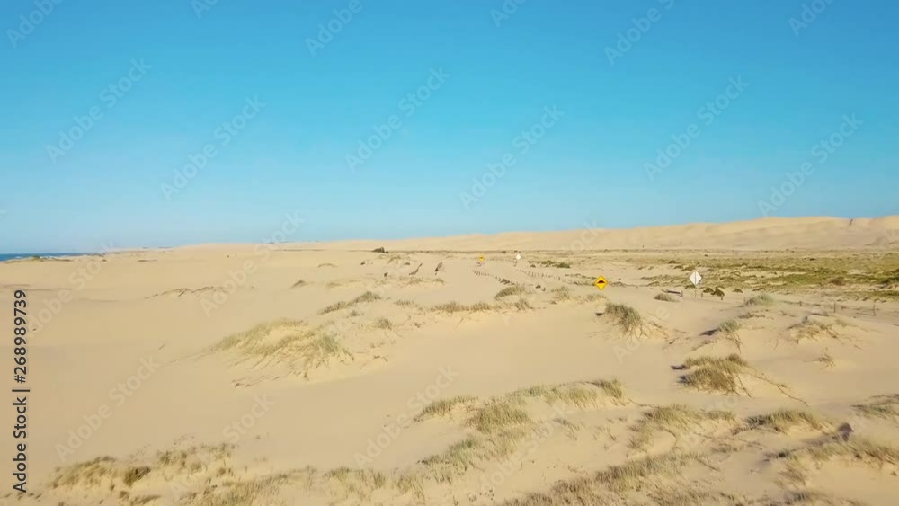 Flying over sand dunes with bright blue skies and no clouds backwards. Flying over sand dunes with bright blue skies and no clouds backwards.