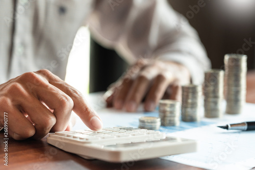 Businessman accountant Calculating on data documents And pile Stack Of coins, the savings money investment. financial Budget planning concept