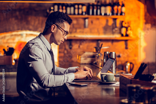 Businessman working remotely sitting at the bar stand