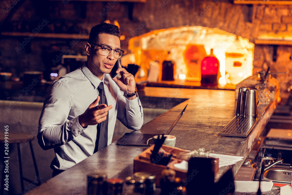 Businessman calling his partner while working remotely in the bar