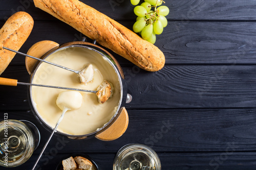 Cheese fondue with bread wine and grape photo