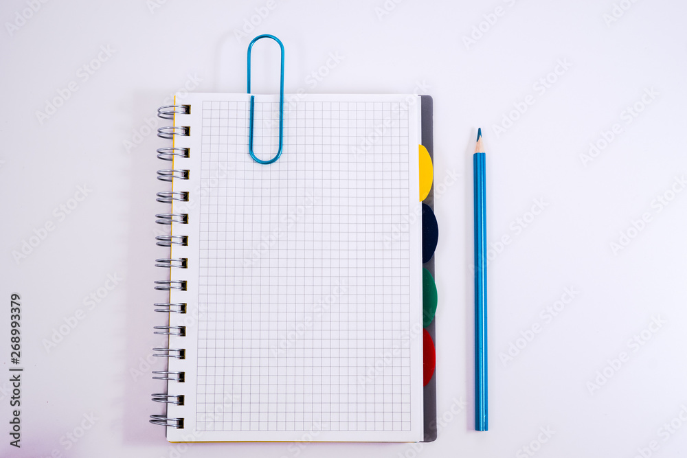 Top view of open spiral blank notebook with pencil on white desk background Top view of open spiral blank notebook with pencil on white desk background