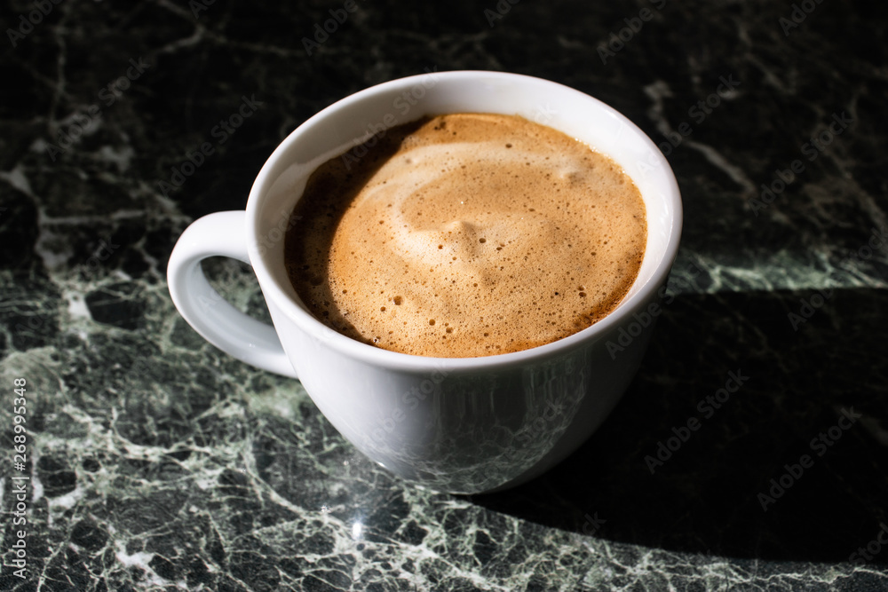 white cup of coffee on green marble background. white cup of coffee on green marble background.
