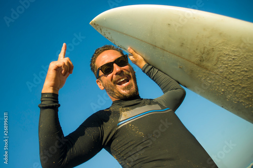 Canvas Print lifestyle portrait of attractive and happy surfer man 3os to 40s in neoprene sur