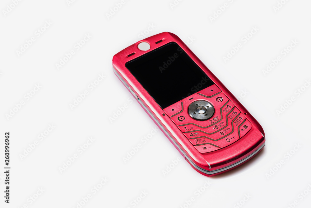 Old, pink mobile phone on white background. Close up. Selective focus. Old, pink mobile phone on white background. Close up. Selective focus.