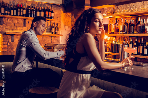 Man looking at beautiful curly woman in the bar photo