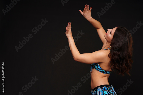 Beautiful belly dancer perfoming exotic dance in red flutter dress photo