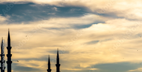 Fotografía Abstract image of the shilouette of four minarets against a dramatic cloudy sky,