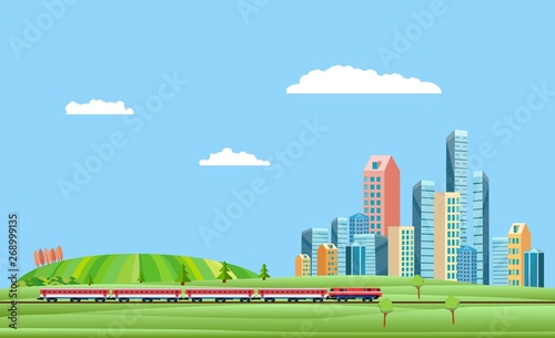 Urban and countryside landscape  with city buildings, train on the railroad . Family houses in town and clouds in the sky green hills in background. 