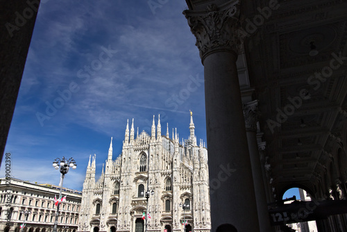 Milan Cathedral facade with  blue sky.  In the foreground the arches of the portico. photo