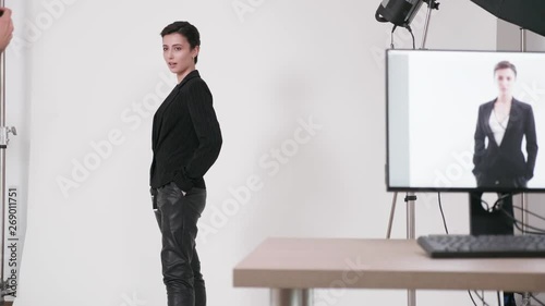 Professional fashion photoshoot in a studio. Model is posing to the photographer