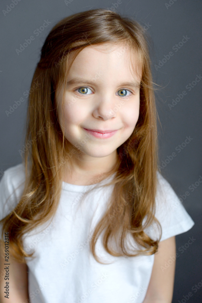 Portrait of beautiful happy girl in white t-shirt isolated on grey background. Portrait of beautiful happy girl in white t-shirt isolated on grey background.