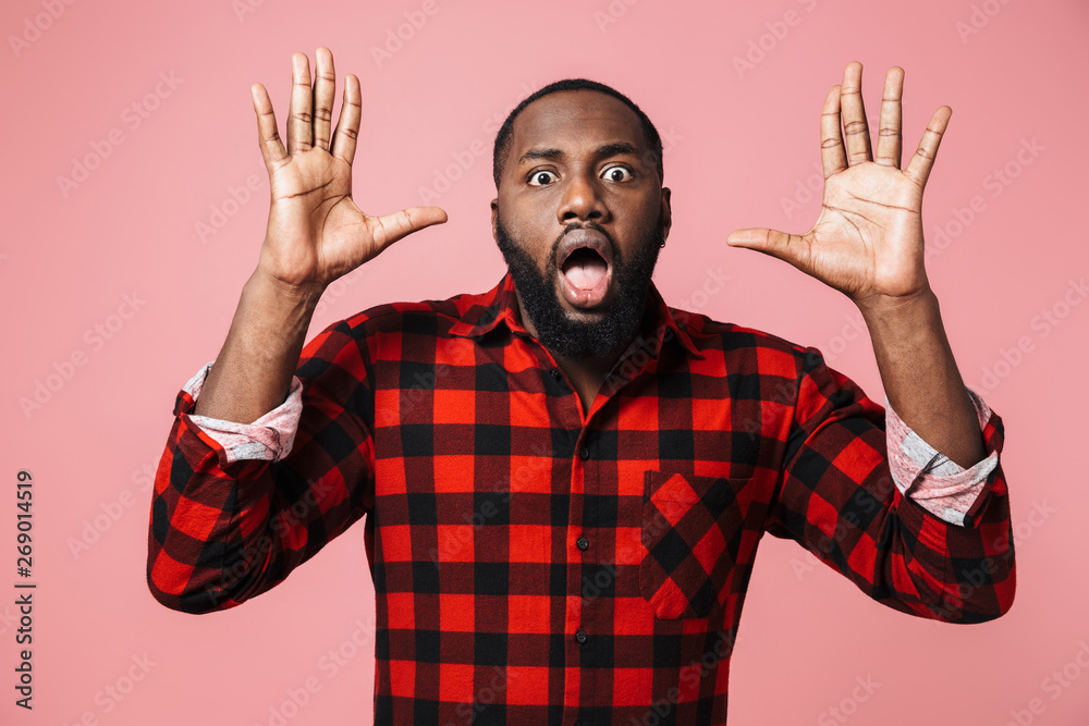 Fototapeta premium Portrait of a shocked african man wearing plaid shirt