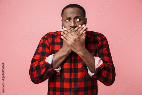 Portrait of a shocked african man wearing plaid shirt