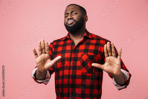 Portrait of an unsatisfied african man wearing plaid shirt