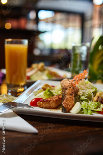 Fried fish caesar salad healthy breakfast or dinner option closeup photography in a restaurant setup